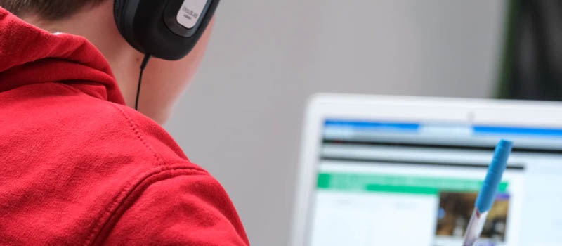 Student on computer wearing headphones